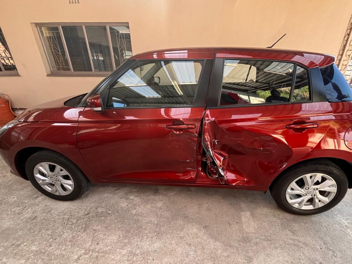 Collision-damaged fourth-generation Suzuki Swift requiring front and rear replacement doors